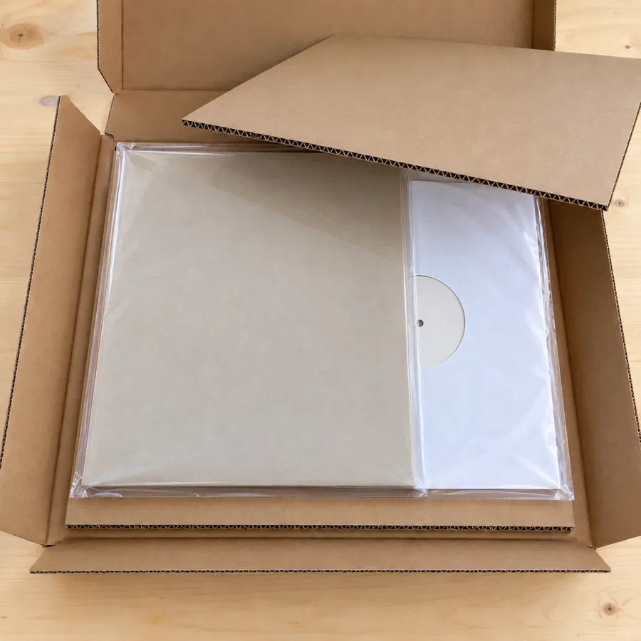 Record and jacket between cardboard stiffeners inside an open LP mailer